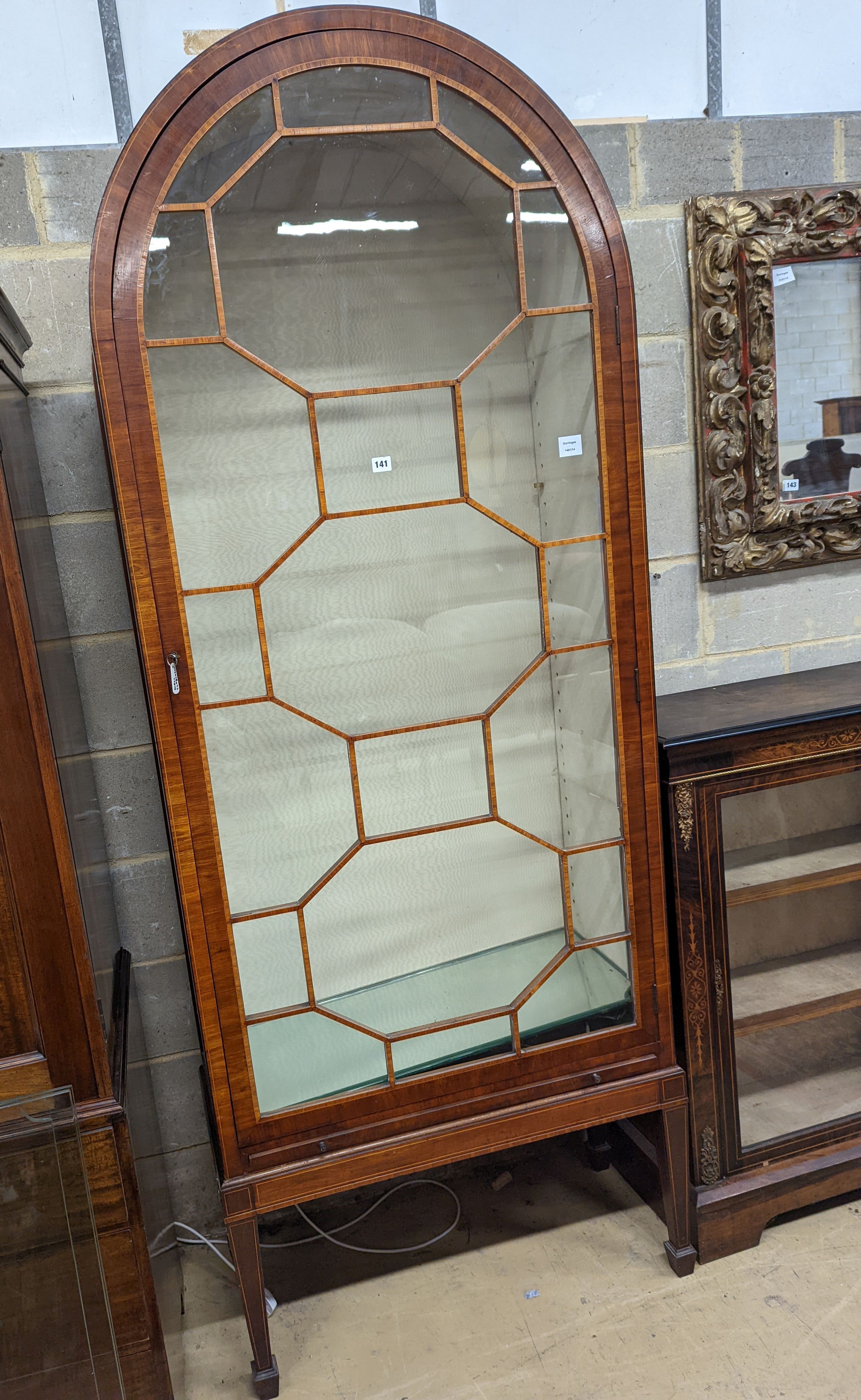 A George III style mahogany and tulipwood banded, domed topped china display cabinet, raised on a stand, width 87cm, depth 39cm, height 225cm